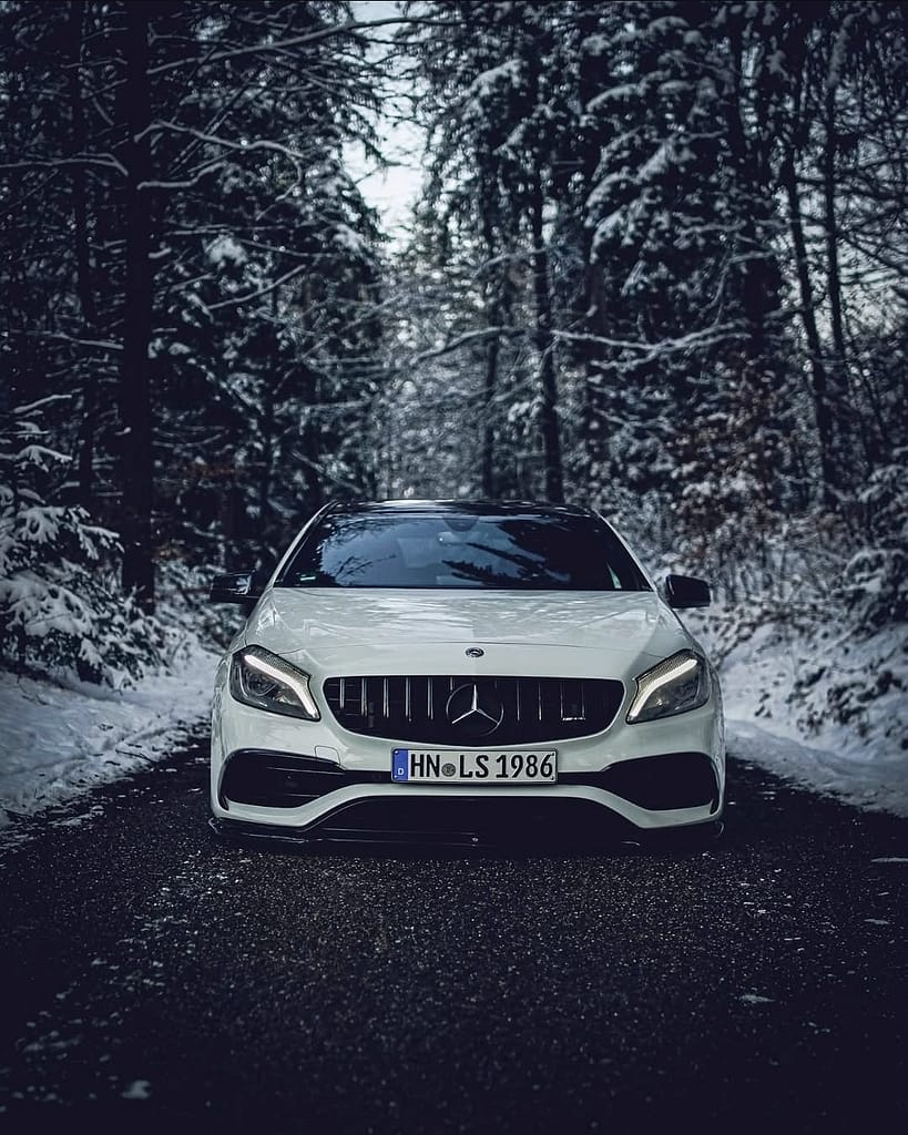 Mercedes-AMG A45 W176 frontal auf dunkler Winterstraße im verschneiten Wald fotografiert