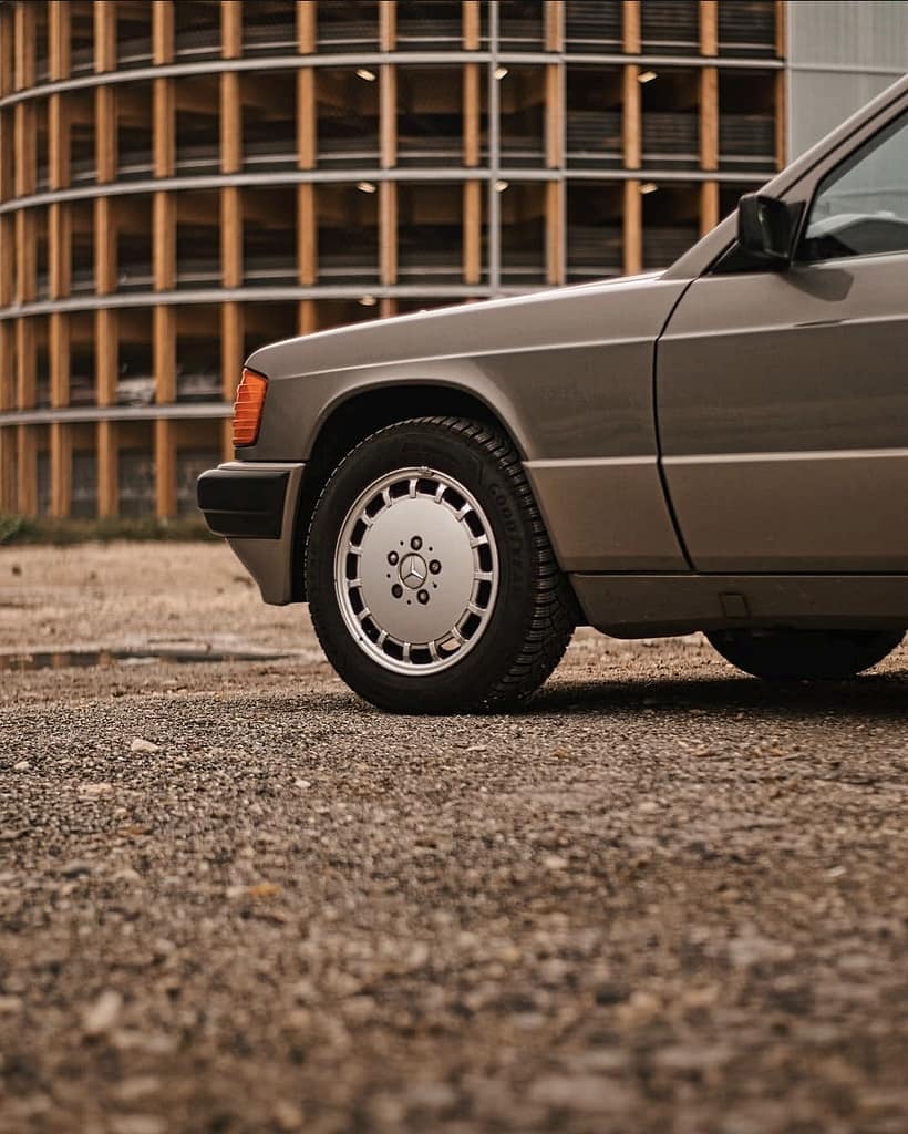 Mercedes-Benz 190E W201 Klassiker in warmer Lichtstimmung fotografiert auf urbanem Gelände – Automotive Fotografie Detailaufnahme Front und Seitenansicht